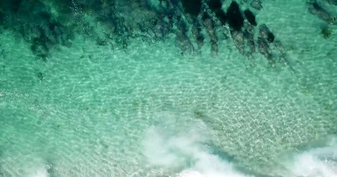 Bird's eye view of serene abstract waves flowing at the shore