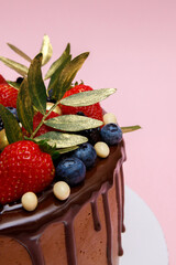 Chocolate cake in chocolate glaze with strawberries, blueberries and blackberries. Cooking and dessert recipes