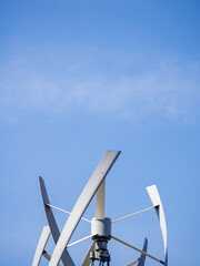 Detail of wind turbine under blue sky.