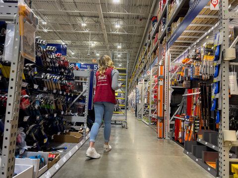 Everett, WA USA - circa September 2022: Wide view of a Lowes employee moving a stair ladder around inside the home improvement store.