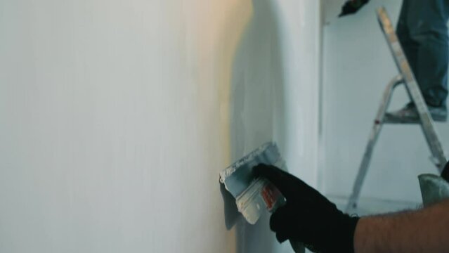 An apartment master does repairs to the apartment in the apartment Specialist painters and plasterers plaster the walls