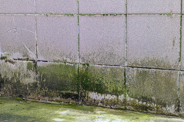 Damage caused by water leakage on building wall outside. Rainwater runs down the wall and damages...