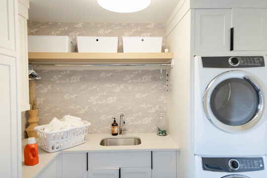 Folded towels in laundry basket on counter in laundry room