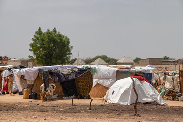 Refugee camp in Africa, full of people who took refuge due to insecurity and armed conflict. People living in very poor conditions, lack of food, clean water and proper shelter to stay in - obrazy, fototapety, plakaty
