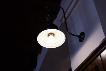 Retro-style lamp on the wall in the dark