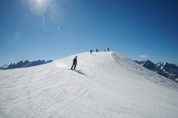 Narciarze na nartach, góry w górach, śnieżny śnieg. Ratrakowane trasy narciarskie.  Sztruksik. Białe szaleństwo i błękitne niebo.. Mroźna zima w Dolomitach. Tatrach, Alpach.