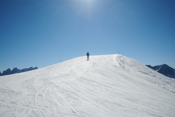 Fototapeta na wymiar Narciarze na nartach, góry w górach, śnieżny śnieg. Ratrakowane trasy narciarskie. Sztruksik. Białe szaleństwo i błękitne niebo.. Mroźna zima w Dolomitach. Tatrach, Alpach.