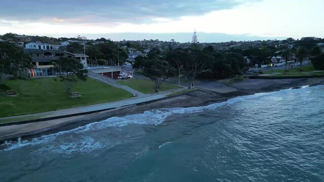 Vertical footage of water floating with grasses, trees and buildings around.