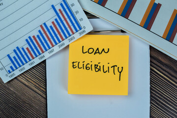 Concept of Loan Eligibility write on sticky notes isolated on Wooden Table.
