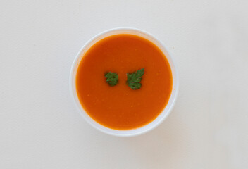 Natural tomato soup in white bowl , top view .