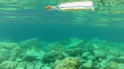 Message in a bottle. A message in a bottle floats on the surface of the sea. Bottle with message at sea