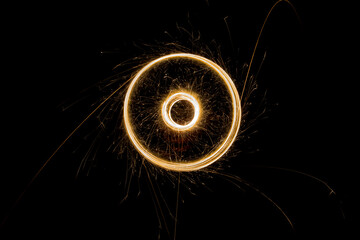 Sparks from the circular rotation of lights on a black background