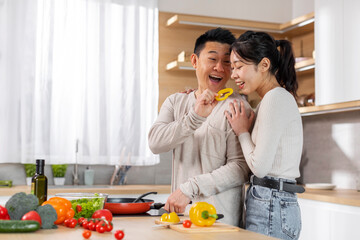 Handsome japanese man cooking dinner for his wife