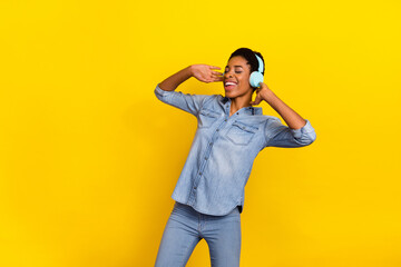 Photo of cheerful overjoyed person hands touch headphones meloman isolated on yellow color background