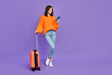 Full size photo of cute young woman hold device taxi service tourist wear trendy orange knitwear outfit isolated on violet color background
