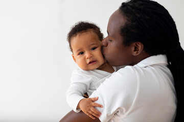 Loving Young Black Dad Holding And Kissing His Adorable Baby Son, Closeup