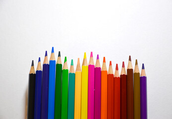 set of colored wooden pencils on a white background. pencils lined up with uneven lines. preparation for drawing