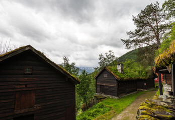Farm Houses Architecture, Snow Capped Mountain Background At Stalheim Open Air Folk Museum With Tonneberg Collection Exhibiting Middle Age Rural Norway In Vossestrand.