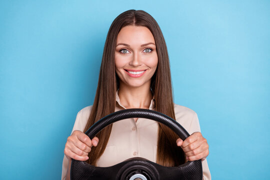 Photo of nice adorable confident positive girl beige shirt hold steering wheel ready for driving lesson isolated on blue color background
