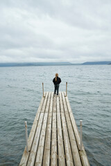 Fototapeta na wymiar Girl admiring sea from pier