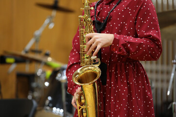 Obraz premium A woman plays a saxophone performing on stage.Musical instrument close up