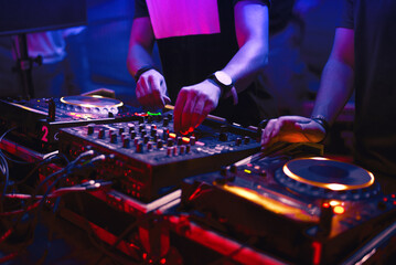 Dj playing techno music on the stage at night summer concert