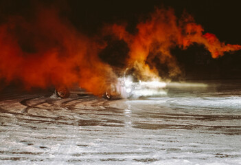 Obraz na płótnie Canvas men ride at night in an SUV with orange smoke