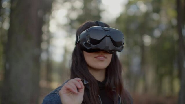 Close up of woman wearing virtual reality goggles interacting with vr interface, nature