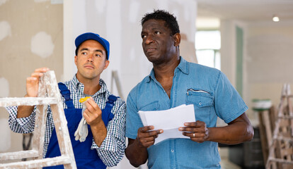 Owner of apartment indicates to the foreman where and what to repair