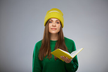 Happy student woman dressed in casual teenage style holding book. Advertising female studio portrait.