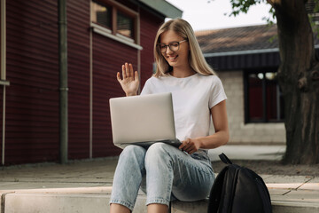 student doing online video broadcasting, She communicates via video call with colleagues with laptop