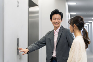 エレベーターに乗る男女 © metamorworks