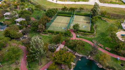 Fototapeta na wymiar Aerial drone view of a paddle tennis court in the middle of a park. Racket sports concept.