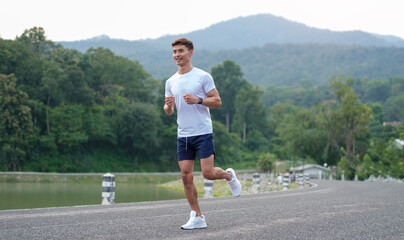 Handsome man running in the park at morning. Fitness, workout and healthy lifestyle concept.