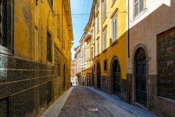 Fototapeta premium A picturesque narrow alley leading to the historic medieval old town walled Città Alta district, in the city of Bergamo, Italy, in the Lombardy region.