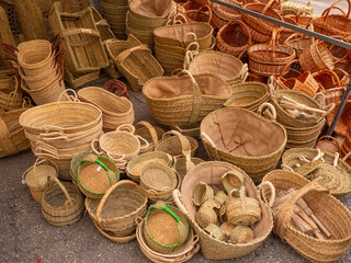 Various handmade baskets for sale on the floor at the market.