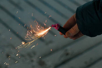 Burning Firecracker with Sparks. Guy Holding a Petard in a Hand. Loud and Dangerous New Year's...