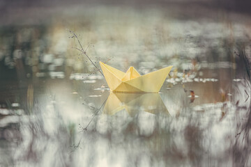 Melancholic portrait of a paper boat in a puddle of water during sundown © Annabell Gsödl