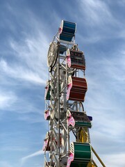 Carnival ride in motion during the day with beautiful blue sky background