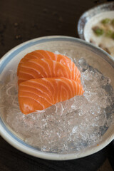 Fresh salmon raw sashimi served on ice eating fresh wasabi