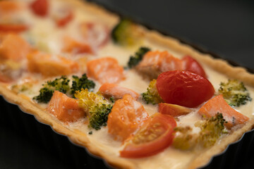 Ready-made quiche with salmon, broccoli and tomatoes. Cooking a pie.