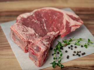 T-Bone Strak with thyme and pepper corn on parchment paper