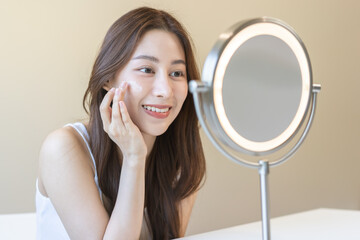 Fresh healthy skin, beautiful smile of asian young woman, girl looking at mirror, applying...