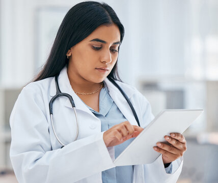 Health, Healthcare And Doctor On Tablet In Hospital Working On Patient Records, Researching Medicine And Planning Schedule. Medical Professional, Female And Worker From India On Tech Browsing Web.