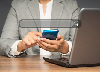 Close-up of hand a businesswoman using a smartphone to search for information on a search engine website while sitting at the table