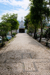 Cobbled tree lined pathway leading to Catholic chapel with crucifix cross in Santa Cruz cemetery in capital city of Dili, Timor Leste, Southeast Asia 
