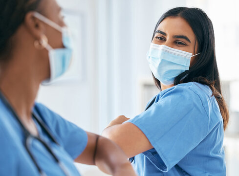 Covid, Women And Doctors Elbow Greeting In Surgical Mask At Hospital Or Clinic During The Pandemic. Teamwork, Healthcare Worker And Medical Professional With Protection From Virus For Doctor Or Nurse