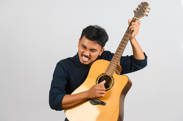 Obraz premium Portrait of Young Asian man playing an acoustic guitar isolated on white background