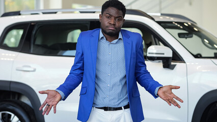 African American man searches money for buying nice car in luxury automobile salon. Poor customer...
