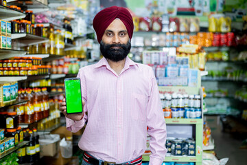 indian small business owner Showing mobile toward the camera